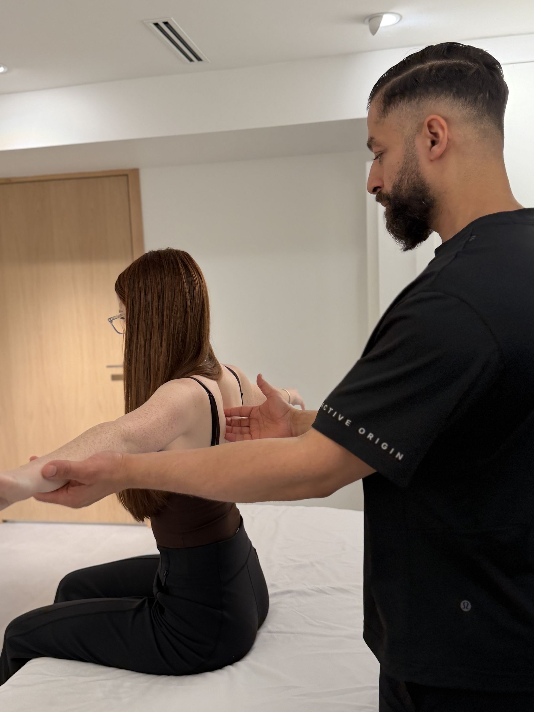 Active Origin registered massage therapist assessing a patient's shoulder blade movement